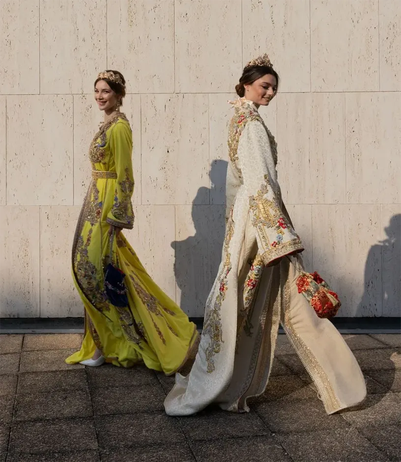 Deux jeunes femmes élégantes portant des tekchitas traditionnelles marocaines, posant avec grâce dans un cadre raffiné.